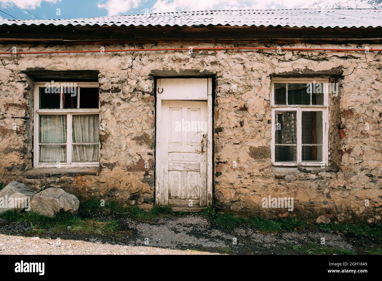 Stepantsminda Gergeti, Georgia. Door Of Old Hillside House In Village. Kazbegi District, Mtskheta-Mtianeti Region, Georgia. Spring Or Summer Season. Stock Photo