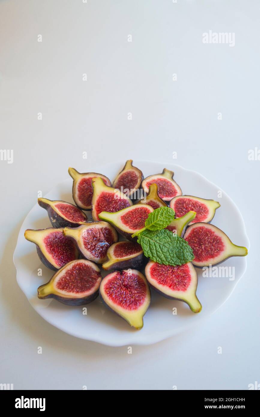 Black figs with mint leaves Stock Photo Alamy