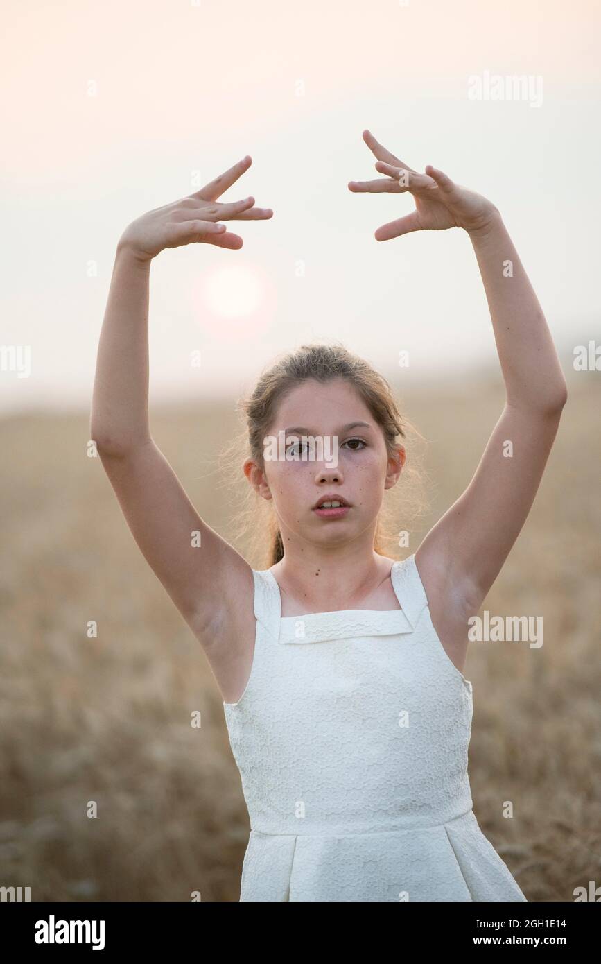 Jeune fille en robe blanche esquissant des pas de danse classique au milieu  d'un champ de cereales au coucher du soleil, France, Europe / Young girl  Stock Photo - Alamy