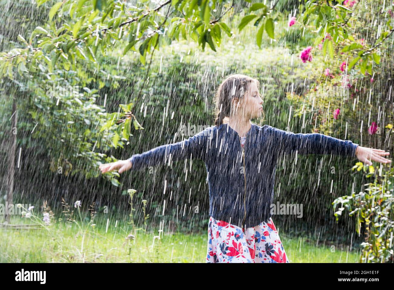 Girl in dress and vest dancing in the rain, France, Europe Stock Photo ...