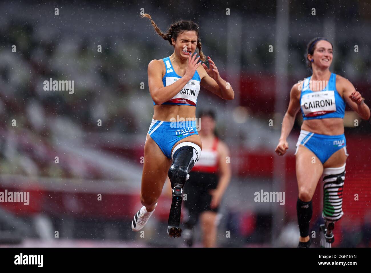 Tokyo 2020 Paralympic Games - Athletics - Women's 100m - T63 Final - Olympic Stadium, Tokyo, Japan - September 4, 2021. Ambra Sabatini of Italy reacts after winning gold and setting a new World Record followed by Martina Caironi of Italy REUTERS/Marko Djurica Stock Photo