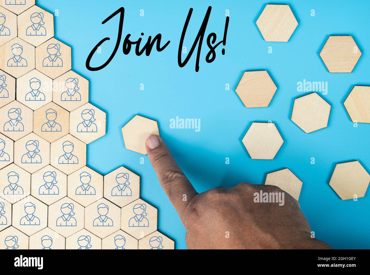 Business concept. Layout of wooden octagon tiles, office employees icons and a hand pushing a blank tile with text. Recruitment process Stock Photo