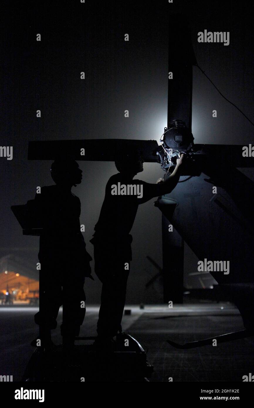 U.S. Marine Corps Lance Cpl. Juan Reyes, left, assists Lance Cpl. Daniel L. Wiggins, both avionics technicians with Marine Light Attack Helicopter Squadron 167, with the the tail rotor of a UH-1N Huey helicopter at Camp Bastion, Helmand province, Afghanistan, June 24, 2013. Reyes and Wiggins rewired a 90 degree gear box to facilitate other maintenance required for the rotor. (U.S. Marine Corps photo by Sgt. Gabriela Garcia/Released) Stock Photo