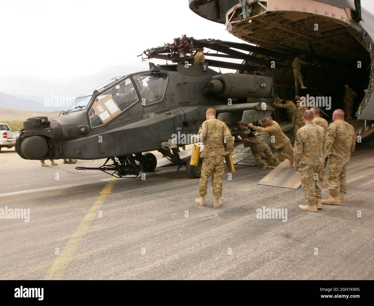 Soldiers from 12th Combat Aviation Brigade, out of Ansbach, Germany, offload an AH-64 Apache helicopter from a C5 Galaxy cargo aircraft in Mazar e Sharif, Afghanistan, on April  28,  2012.  The brigade is  deploying to Afghanistan's Regional Command North in support of Operation Enduring Freedom.  (Photo by Maj. John C. Crotzer) Stock Photo