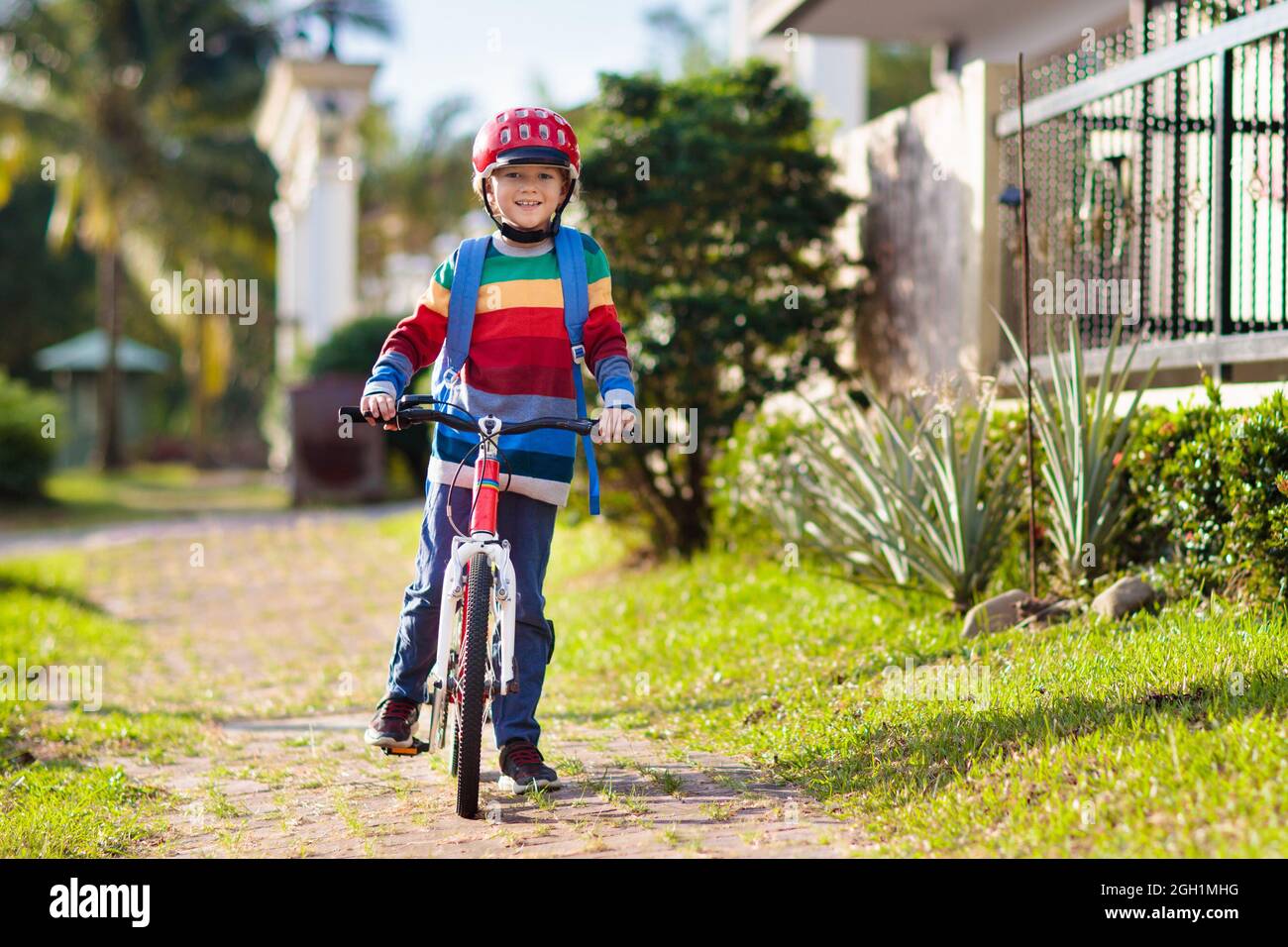 Child going to school on bike. Kids ride bicycle. Safe way to elementary school. Little boy with