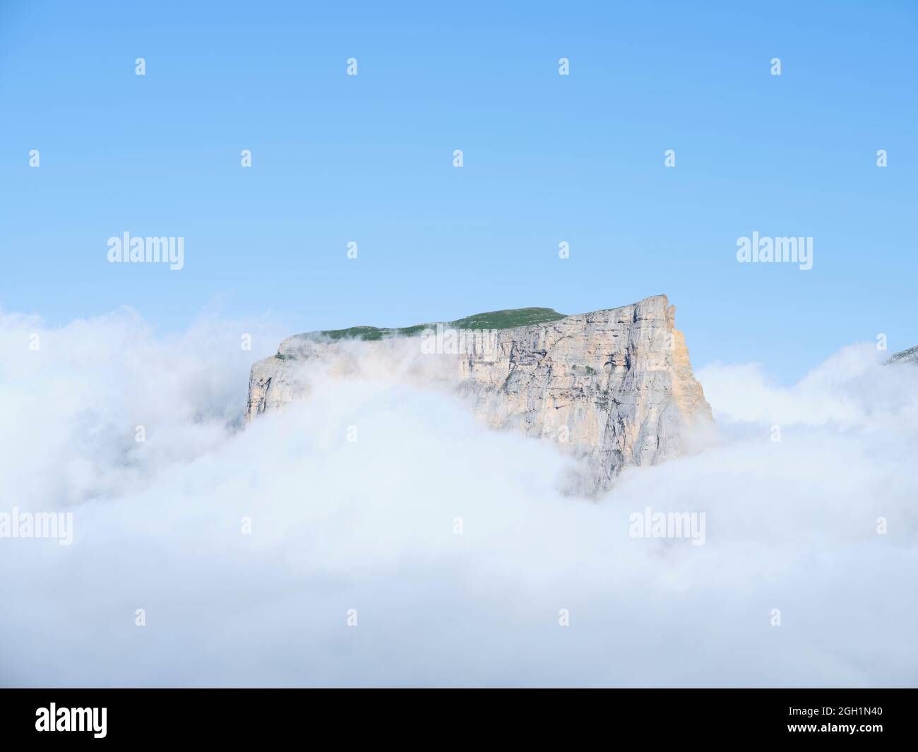 AERIAL VIEW. Mont Aiguille, an isolated limestone butte emerging from a sea of clouds. Saint-Martin de Clelles, Vercors Mountain, Isère, France. Stock Photo