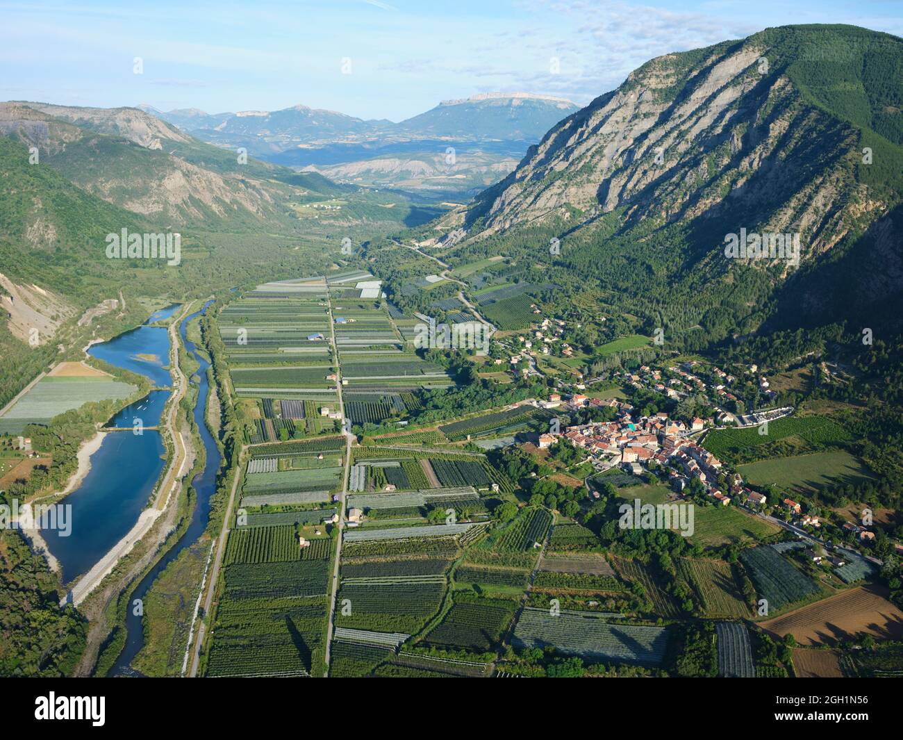 AERIAL VIEW. Village of Remollon on the right bank of the Durance River with its apple orchards. Hautes-Alpes, France. Stock Photo