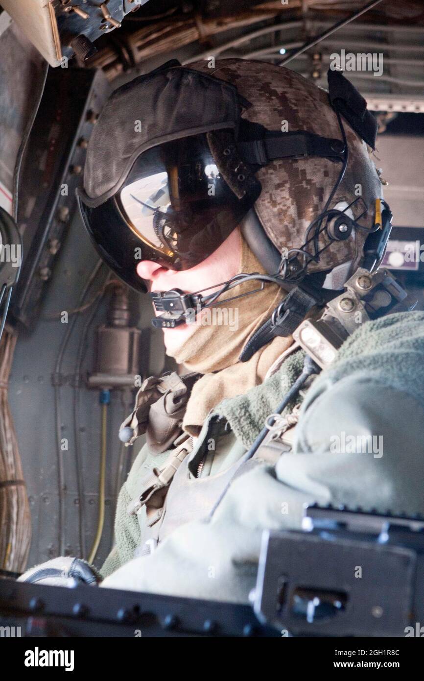 U.S. Marine Corps Gunnery Sgt. Jeremy Miller, crew chief, Marine Heavy Helicopter Squadron 363 (HMH-363), observes the terrain during a routine flight operation, Helmand River Valley, Helmand province, Afghanistan, Jan. 5, 2012. HMH-363 conducted flight operations in support of troops throughout the Helmand province. Stock Photo