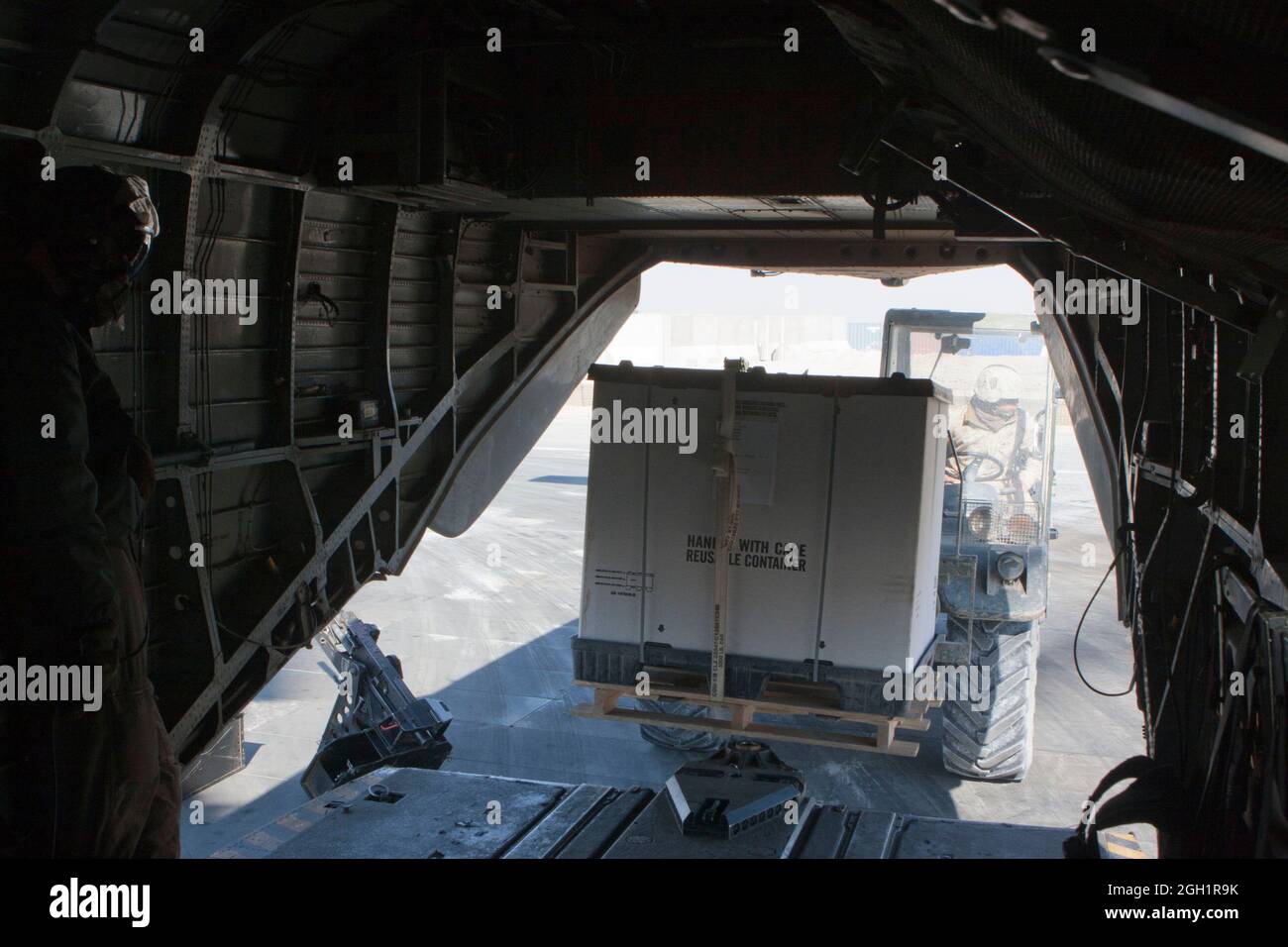 U.S. Marines of Marine Heavy Helicopter Squadron 363 (HMH-363) and Marine Wing Support Squadron 371, load gear onto a CH-53D Sea Stallion helicopter during a heliborne flight operation, Camp Bastion, Helmand Province, Afghanistan, Jan. 5, 2012. HMH-363 conducted flight operations in support of troops throughout the Helmand Province. Stock Photo