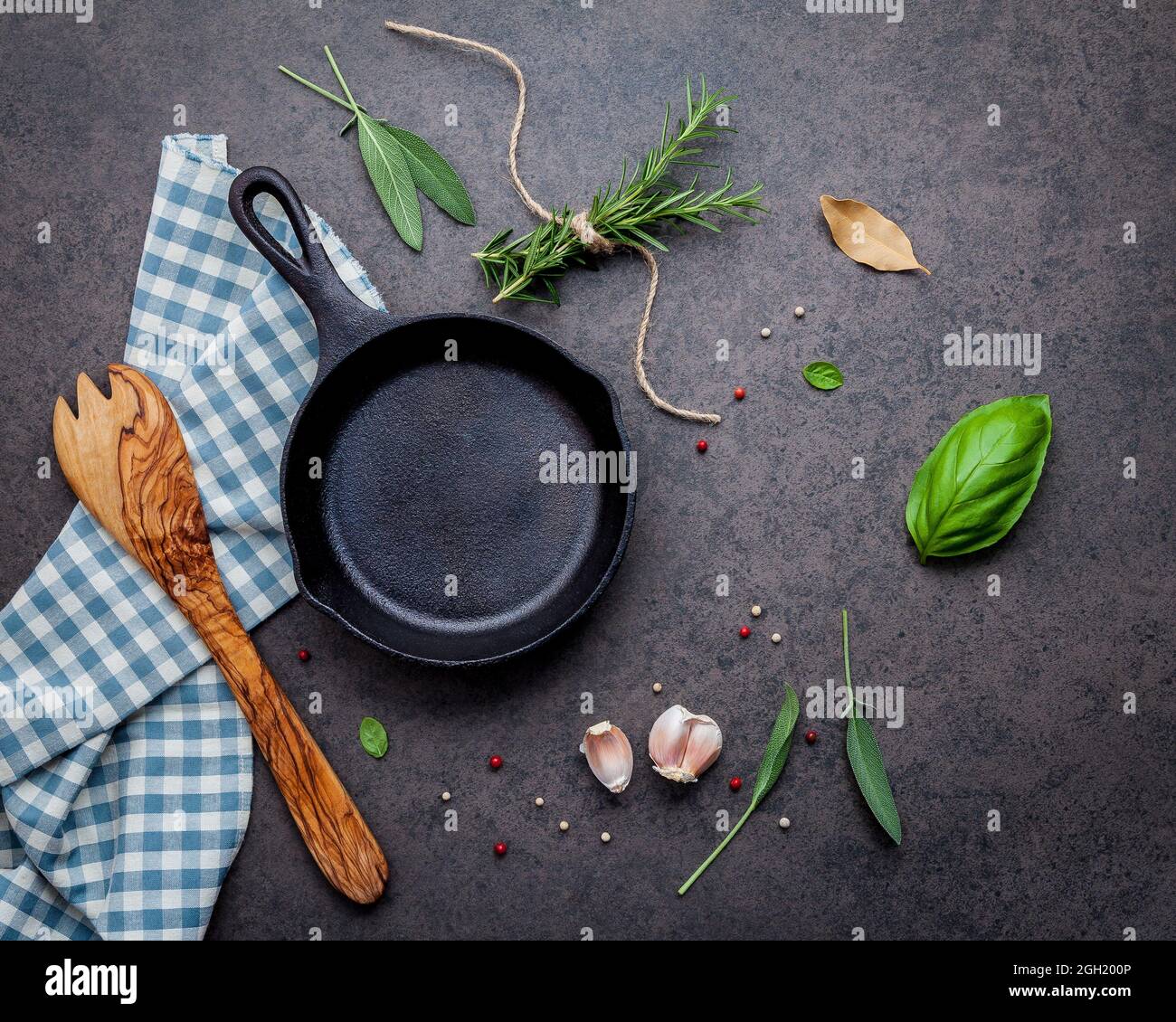 Empty old cast iron skille on dark stone background. Ingredients for