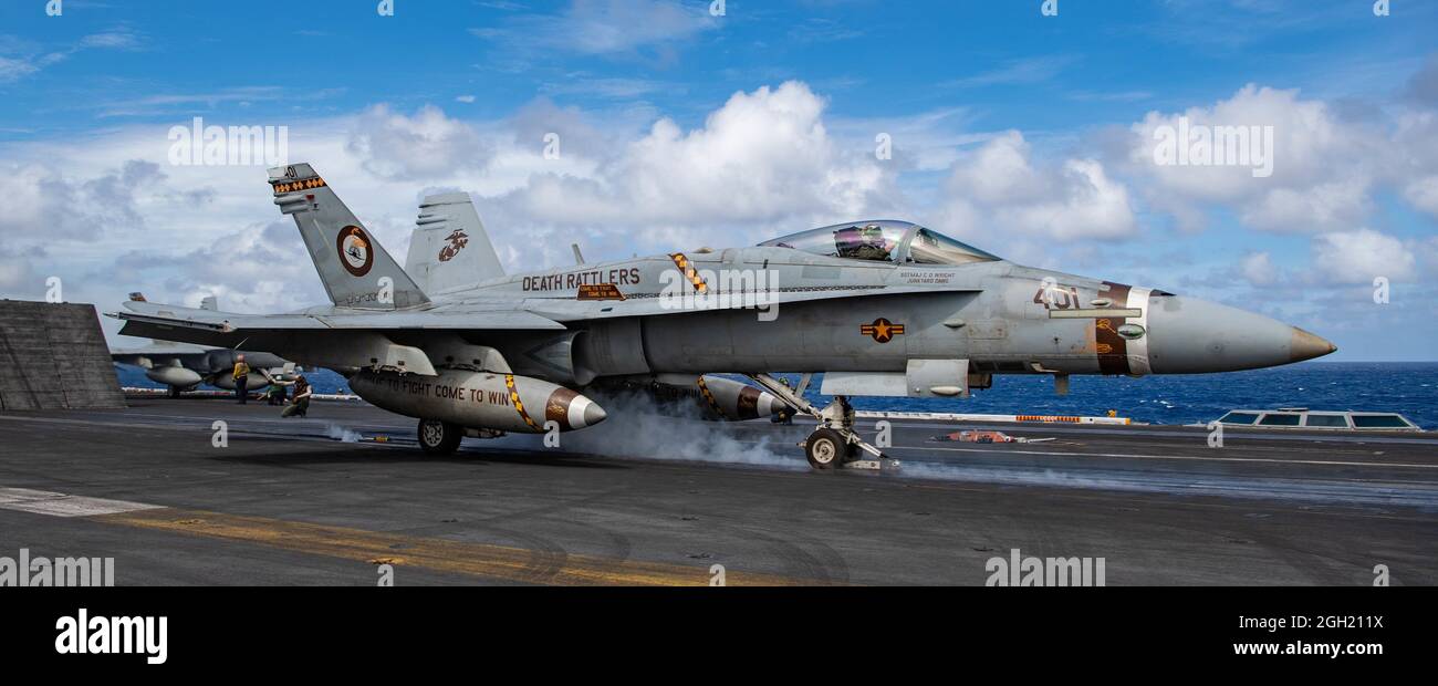 PACIFIC OCEAN (Feb. 19, 2021) An F/A-18C Hornet from the “Death Rattlers” of Marine Fighter Attack Squadron (VMFA) 323 launches off the flight deck of Stock Photo
