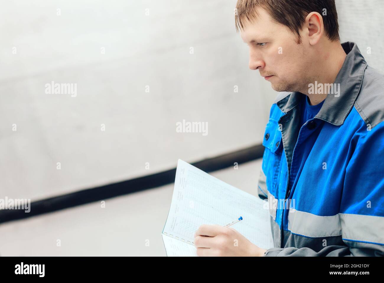 Engineer, worker registers readings of sensors and pressure gauges. Control of water supply and heating system. Checking the equipment before the start of the heating season Stock Photo