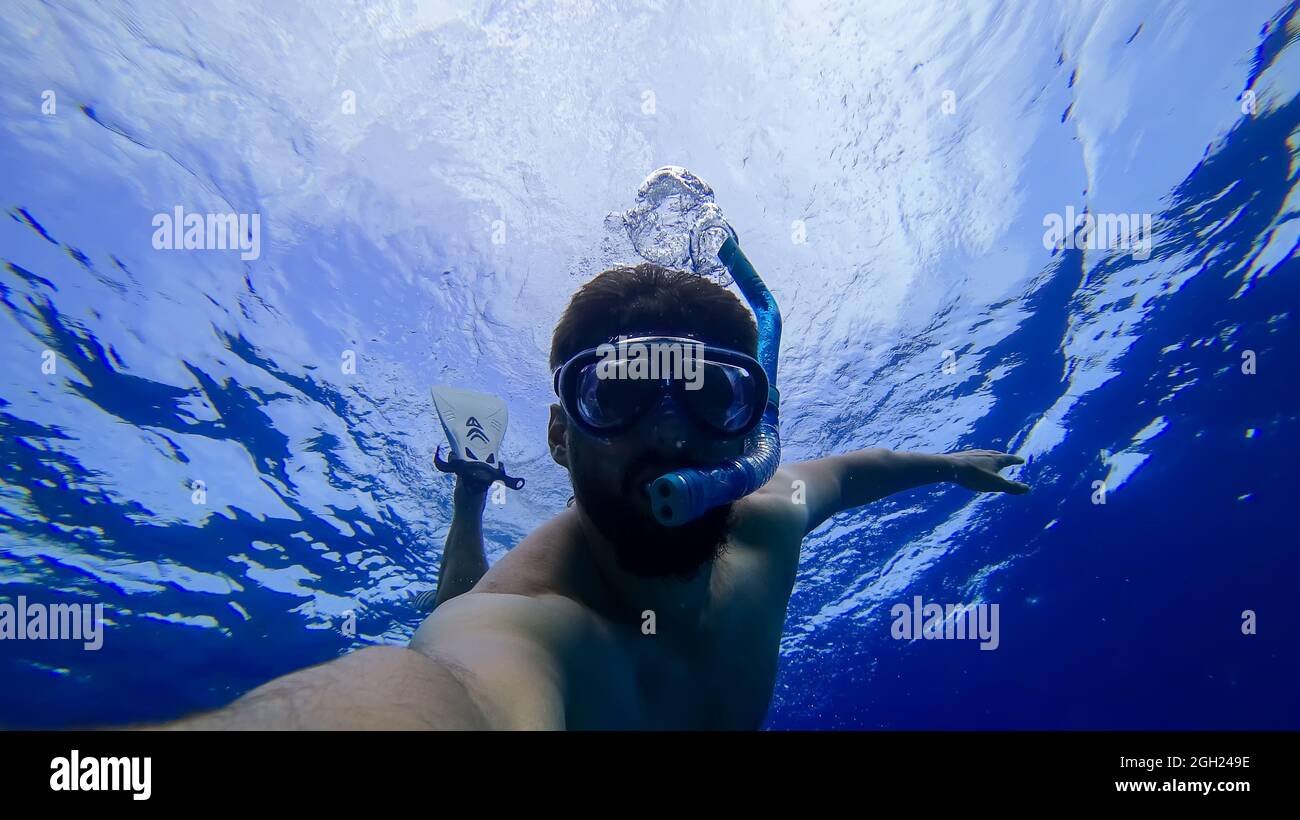a man is engaged in snorkeling diving into the depths of the red sea in a mask and a breathing