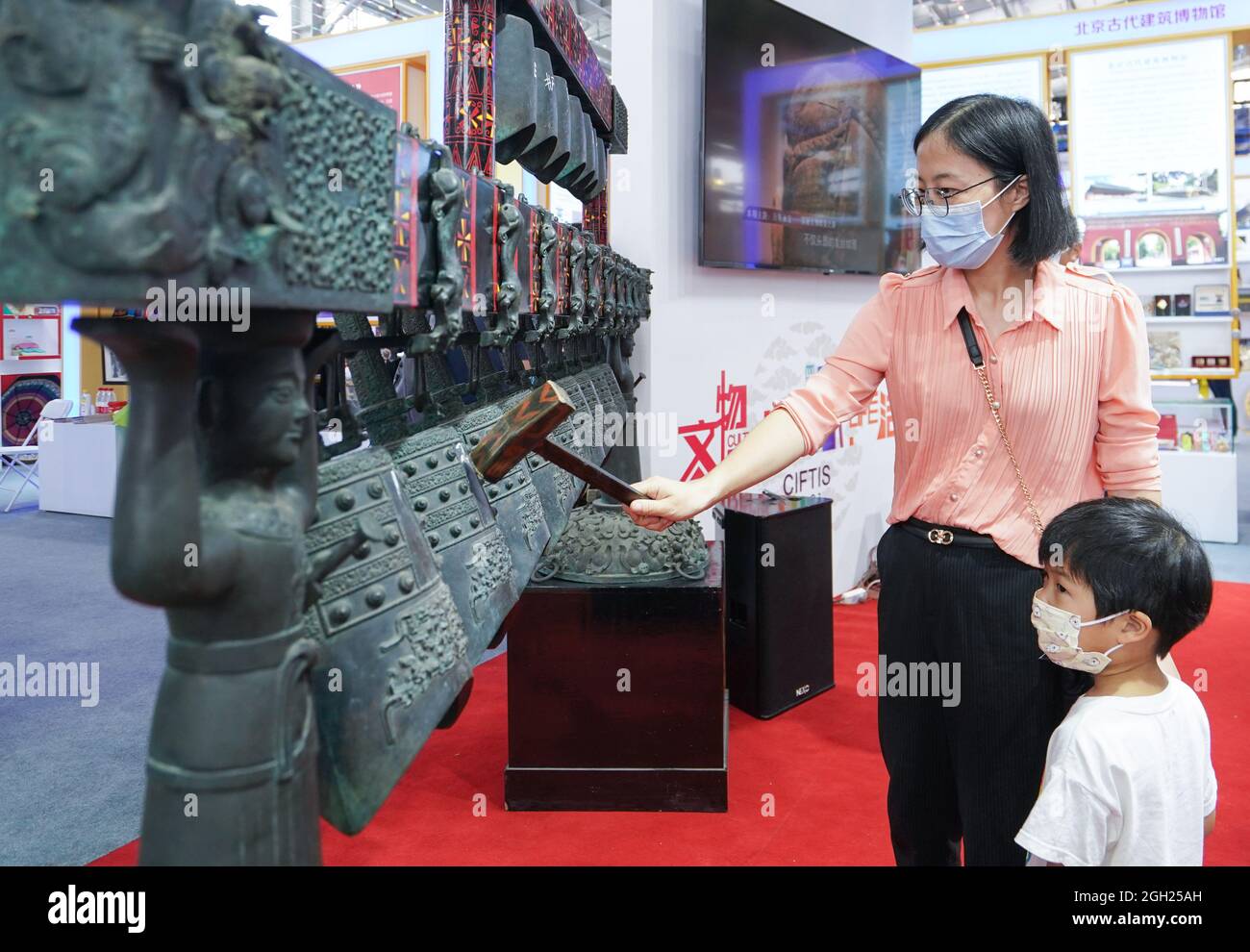 Beijing, China. 4th Sep, 2021. A visitor rings the duplicate of Zenghouyi bronze chime bell in cultural tourism services exhibition hall during the 2021 China International Fair for Trade in Services (CIFTIS) in Beijing, capital of China, Sept. 4, 2021. Credit: Chen Yehua/Xinhua/Alamy Live News Stock Photo