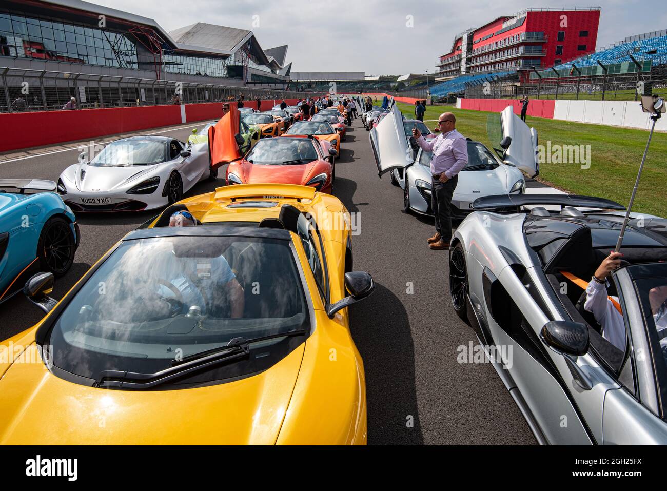 McLaren supercars line up on the starting grid at the Silverstone Circuit for a parade by members of the McLaren Owners Club Stock Photo