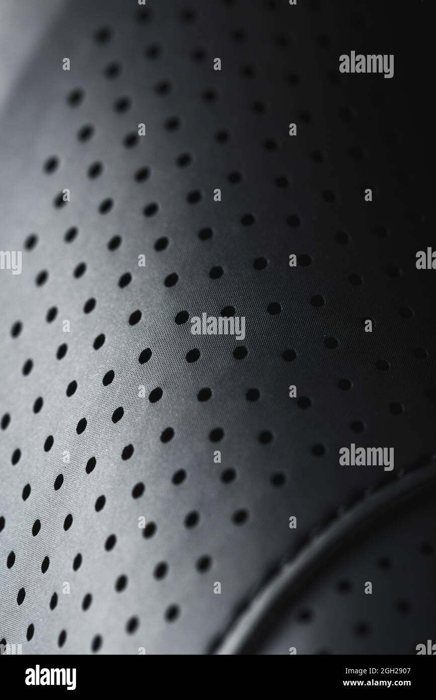 Perforated material made of black imitation leather in full screen. Close-up Stock Photo