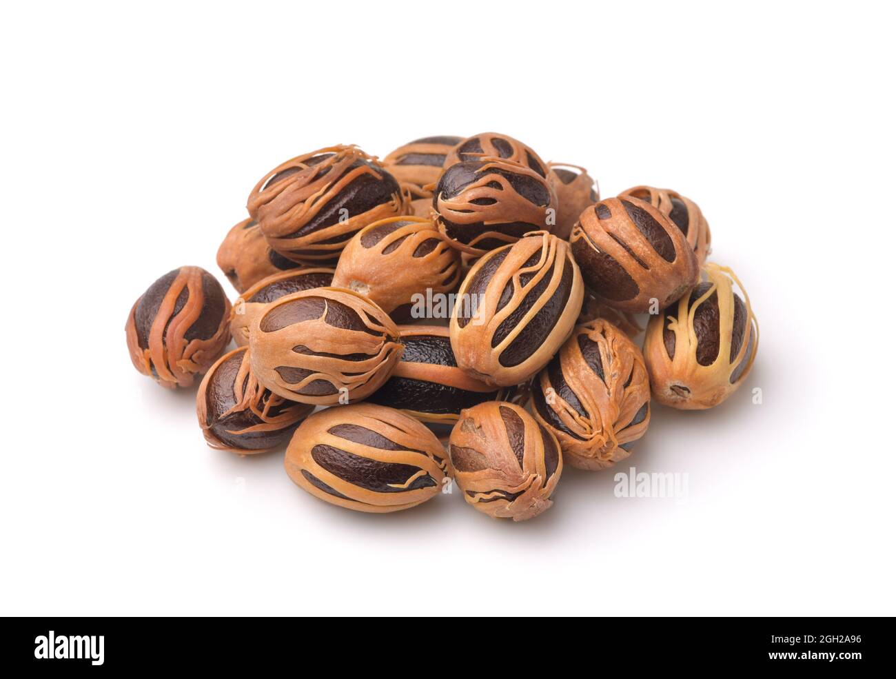 Pile of whole nutmeg with mace isolated on white Stock Photo