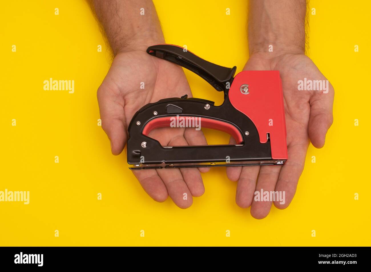 construction stapler gun in the hands. close-up Stock Photo
