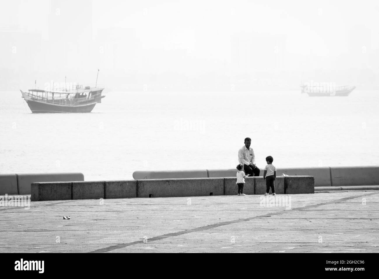 DOHA, QATAR - Mar 01, 2019: A closeup shot of a small cute coastal view with children and their father from The Doha Corniche Stock Photo