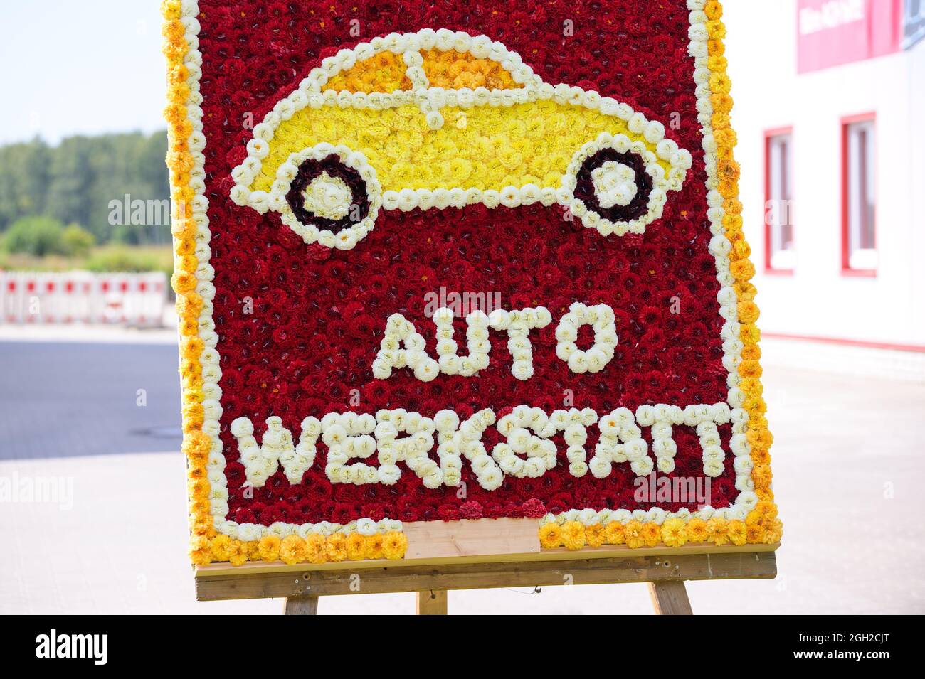 Wiesmoor, Germany. 04th Sep, 2021. 'Autowerkstatt' is written on a colorful stele, which was staked with dahlia flowers by Wiesmoor clubs and institutions. After a one-year break due to corona, a new blossom queen has been elected at the blossom festival in Wiesmoor, East Frisia. Credit: Jonas Walzberg/dpa/Alamy Live News Stock Photo