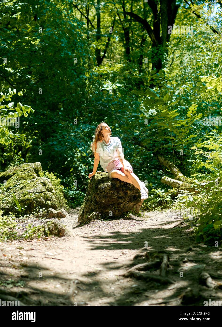 Child blond girl sitting on a rock by the river summer sunlight Stock ...