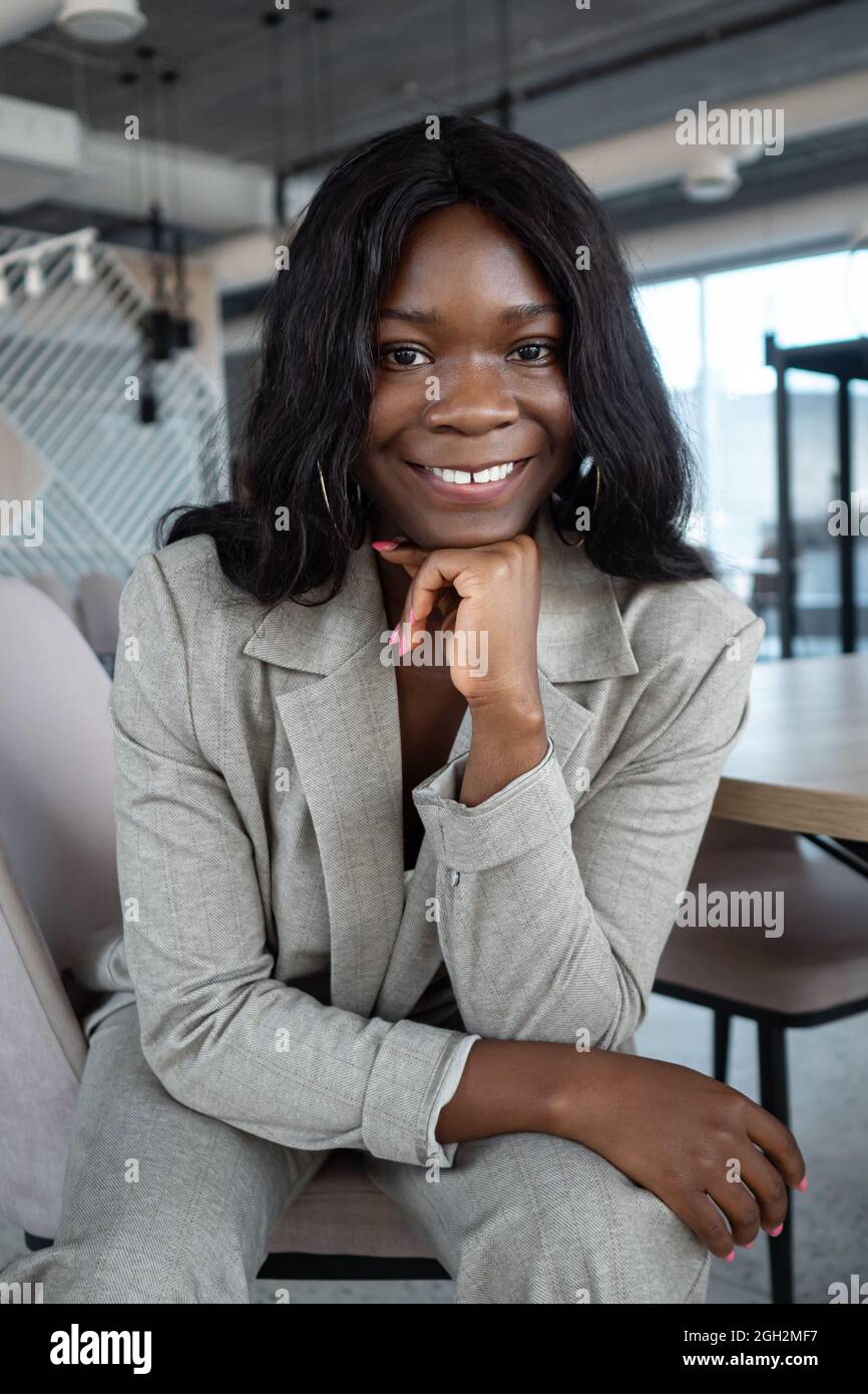 portrait of african american woman in business suit sitting on a chair ...