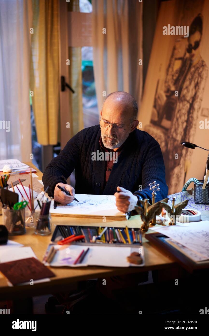 Artist working in the studio. Middle-aged man making creative artwork. Stock Photo