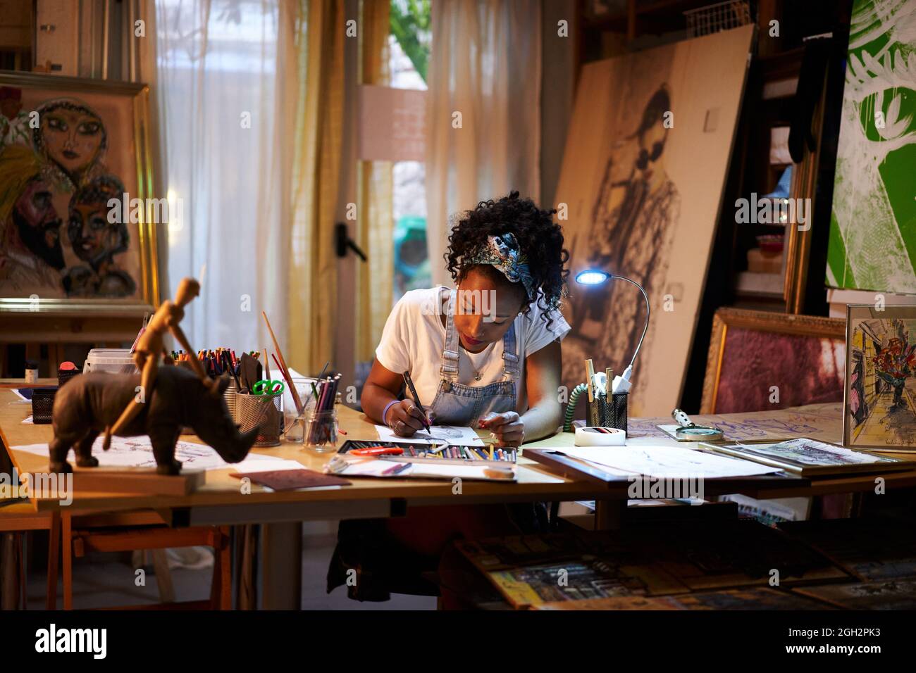Young African-American artist at work in the studio. Creative person making art. Stock Photo