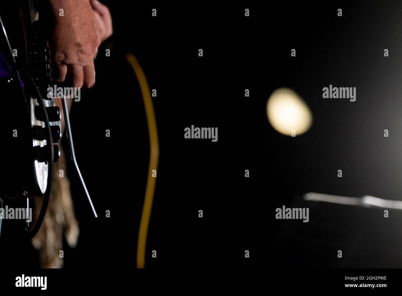 Detail of a person's hand playing an electric guitar. Tab for electric