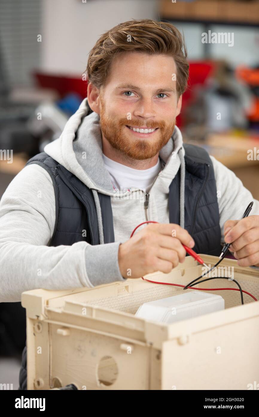 side view of smiling handsome electrician repairing electrical box Stock Photo Alamy