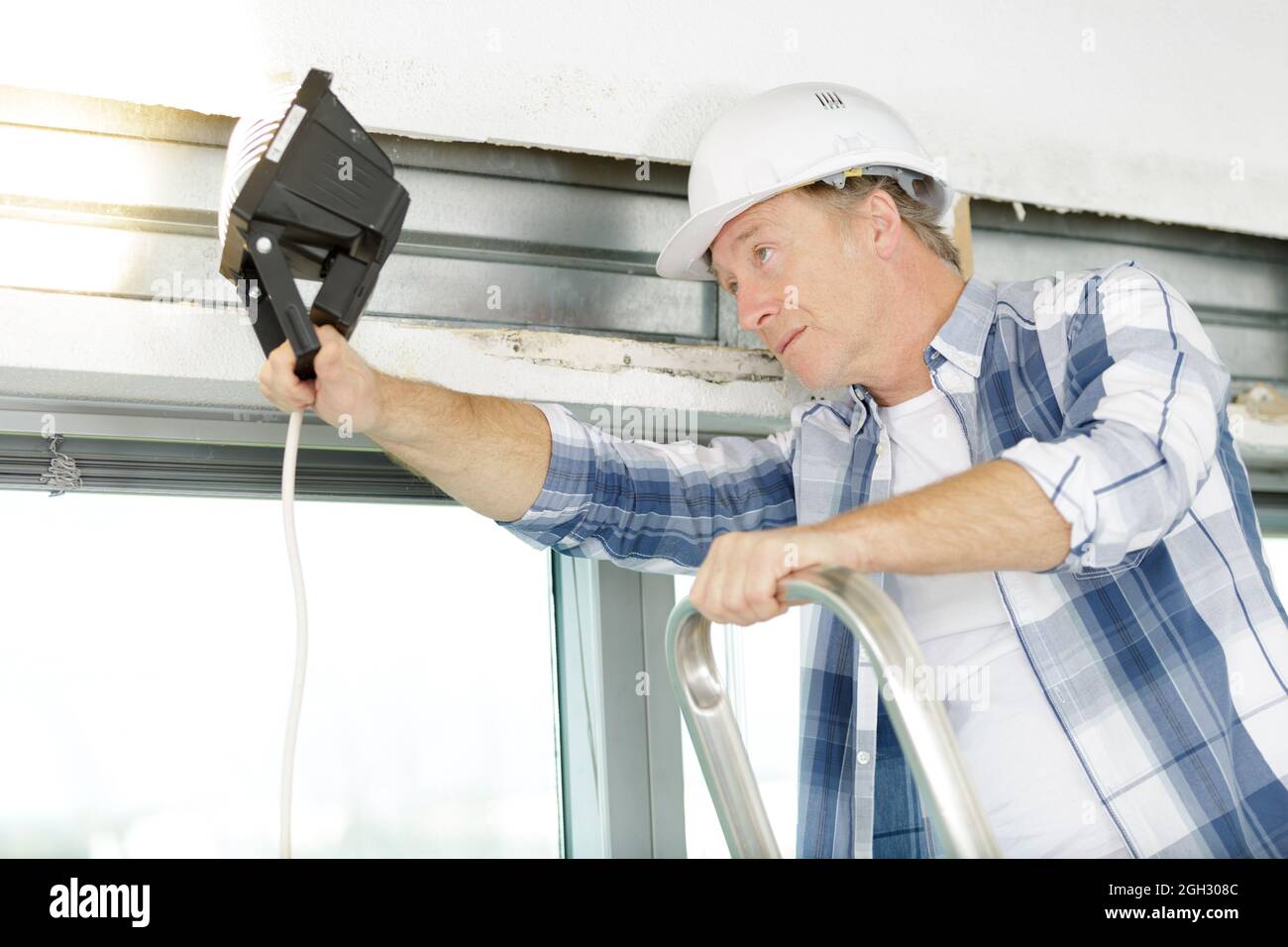 senior man checking the state of a window Stock Photo
