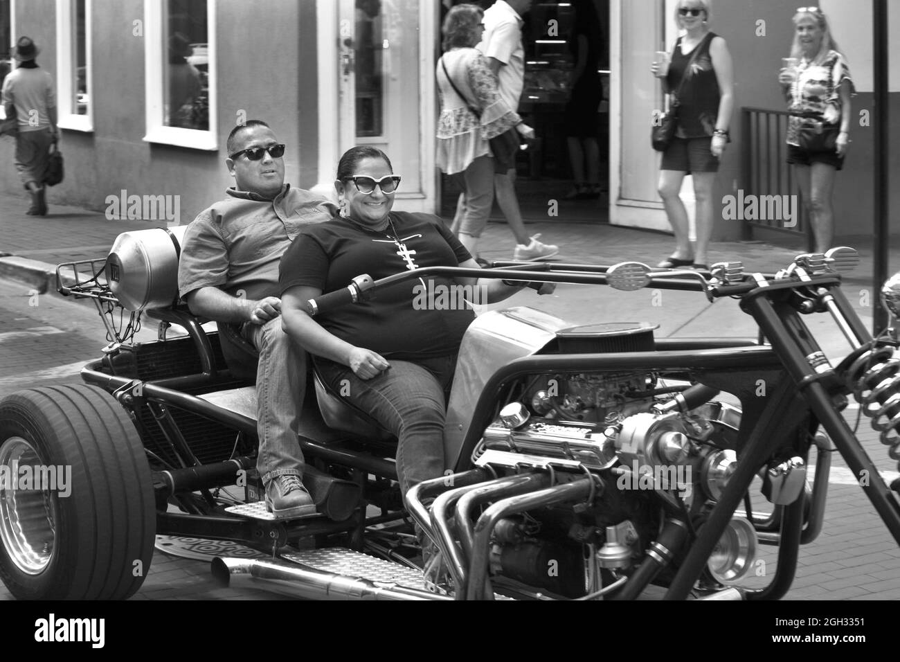 A couple turn heads as they ride their homemade customized motorcycle trike through downtown Santa Fe, New Mexico. Stock Photo