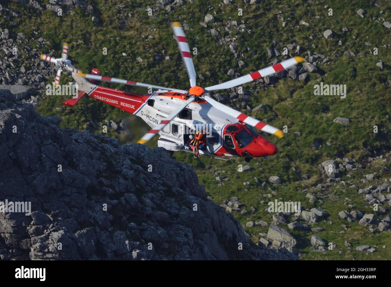 An AW189 helicopter of Her Majesty's coastguard carrying out a mountain rescue on the north face of Ben Nevis, Scottish Highlands, UK Stock Photo