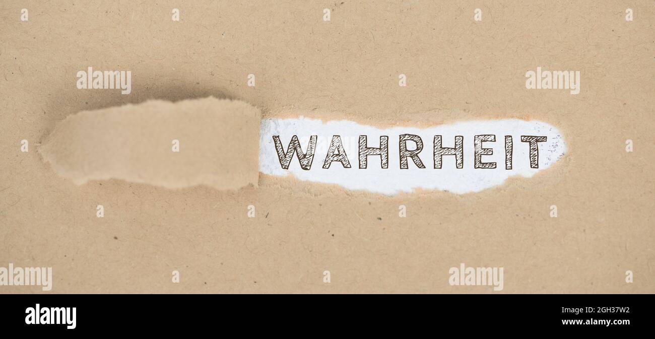 The words the truth standing on a ripped up paper, german Wahrheit Stock Photo