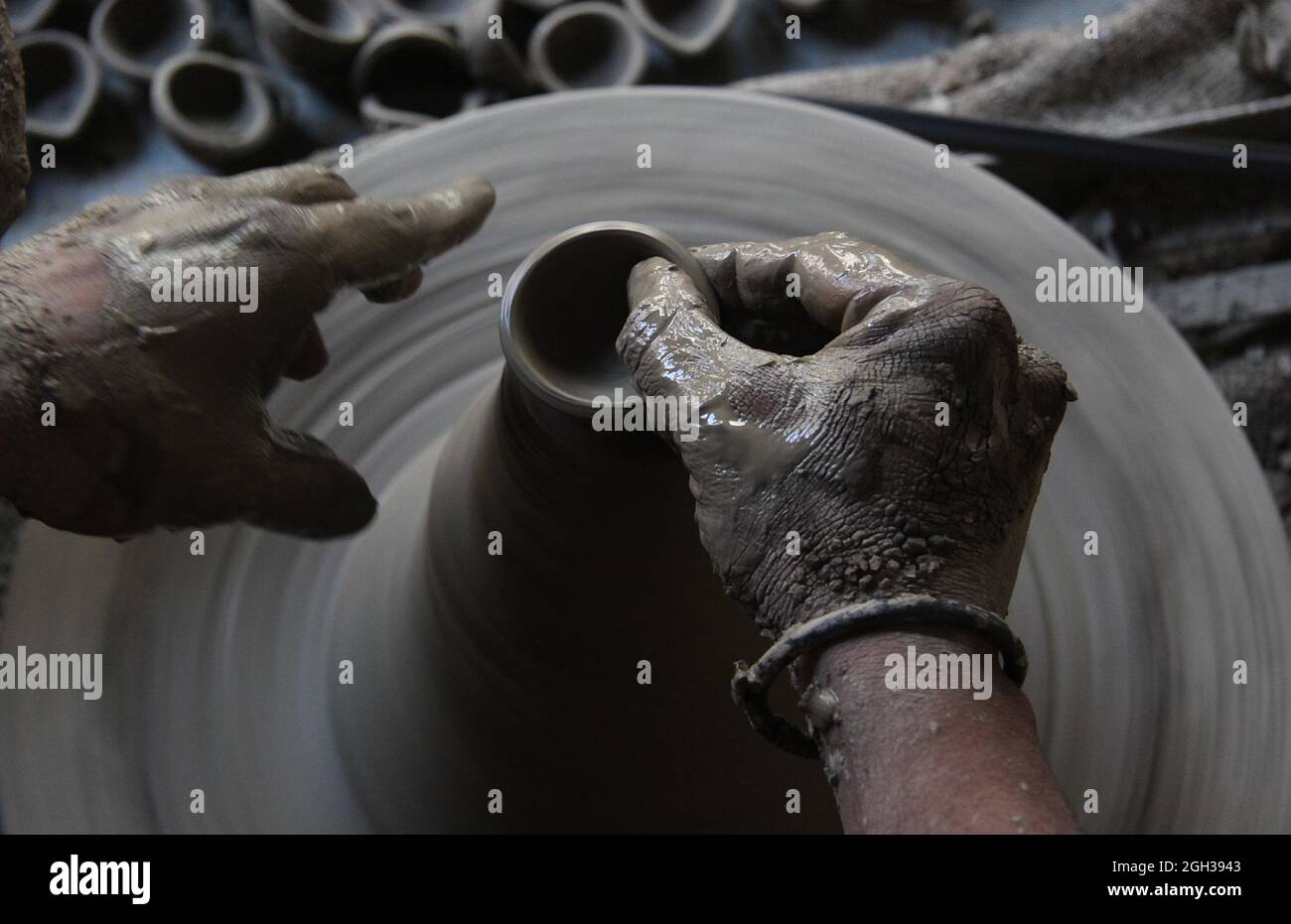 Indian potters give shape to earthenware at their  workshop in potters village in New Delhi .  Potters village is situated in New Delhi's Uttam Nagar . Stock Photo