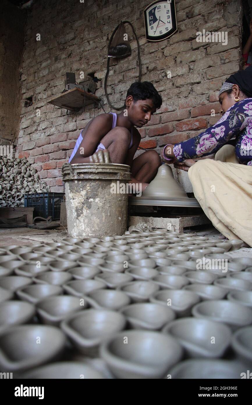 Indian potters give shape to earthenware at their  workshop in potters village in New Delhi .  Potters village is situated in New Delhi's Uttam Nagar . Stock Photo