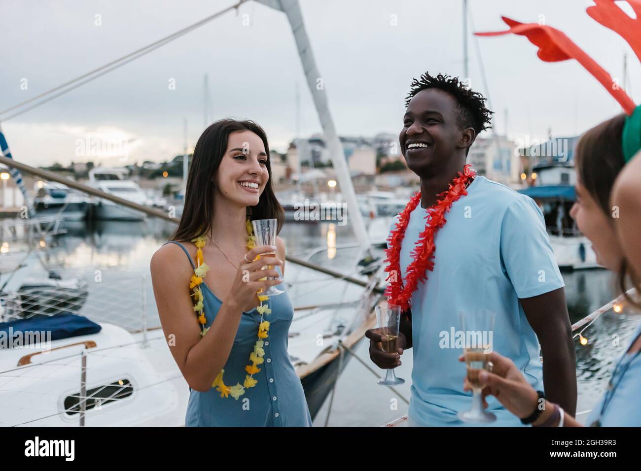 Multiracial friends celebrating together and toasting champagne on a boat  Stock Photo