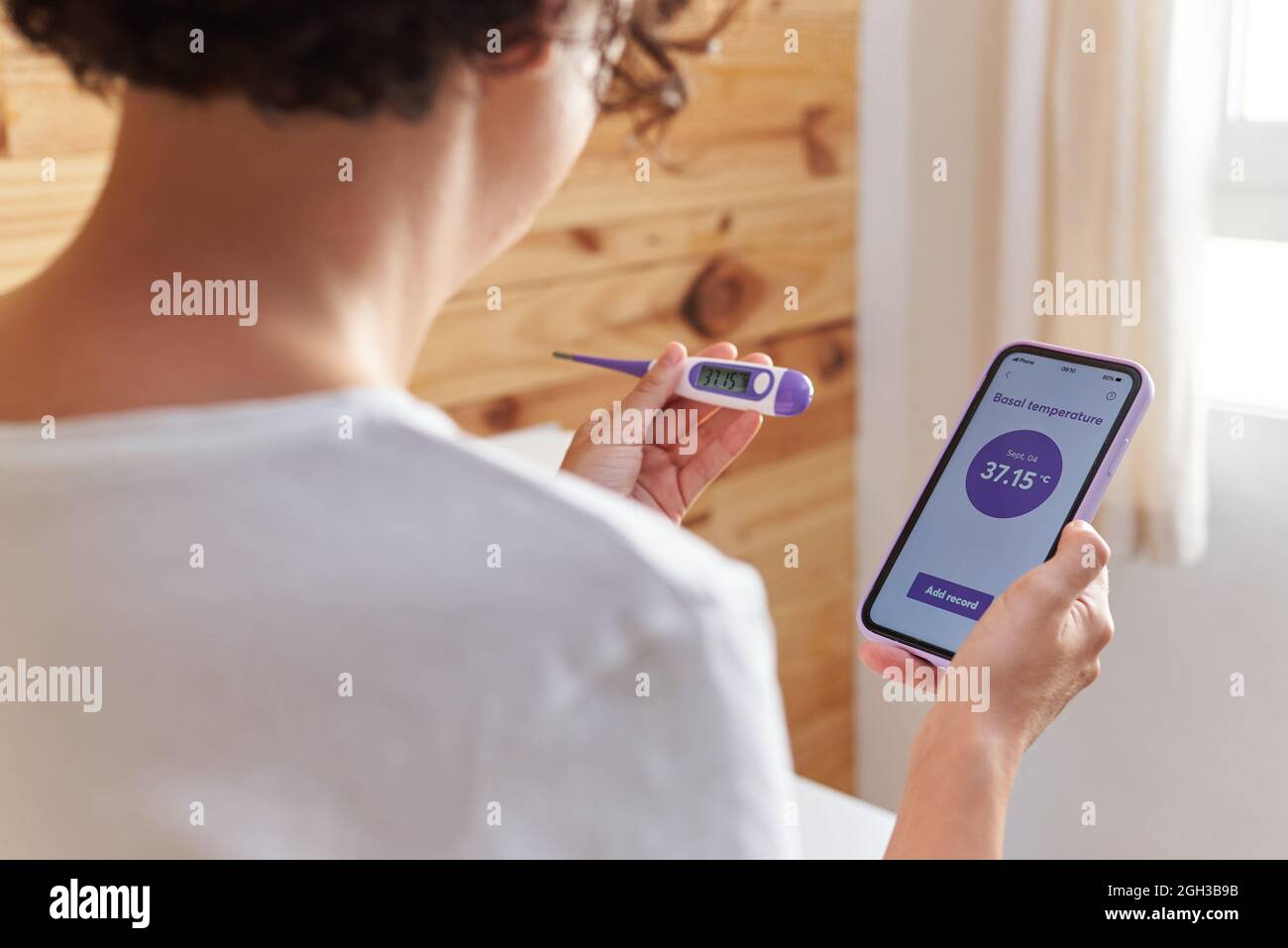 An unrecognizable woman writes down her basal temperature on her