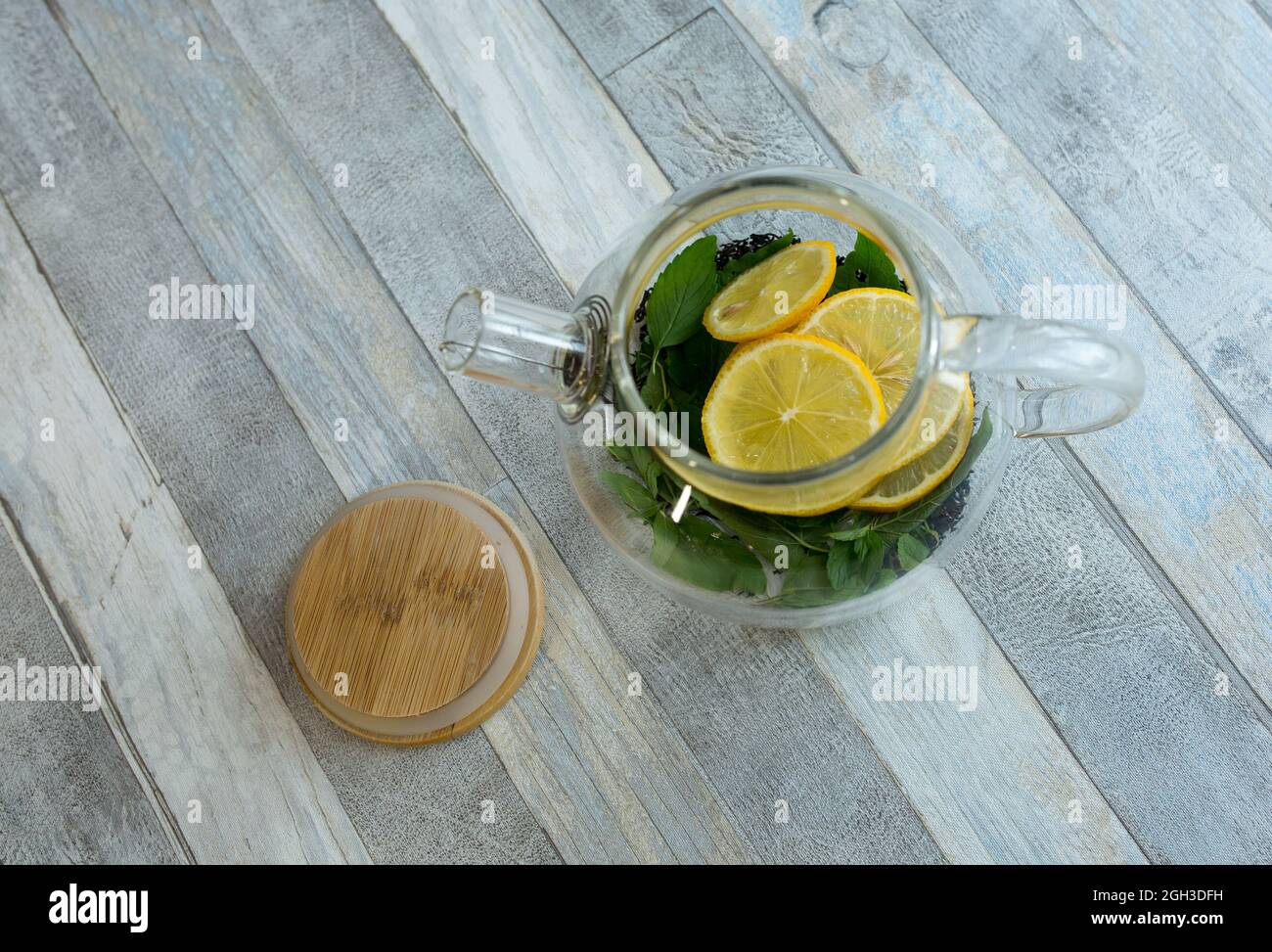 Teapot with mint, tea and sliced lemon before brewing.The process of ...