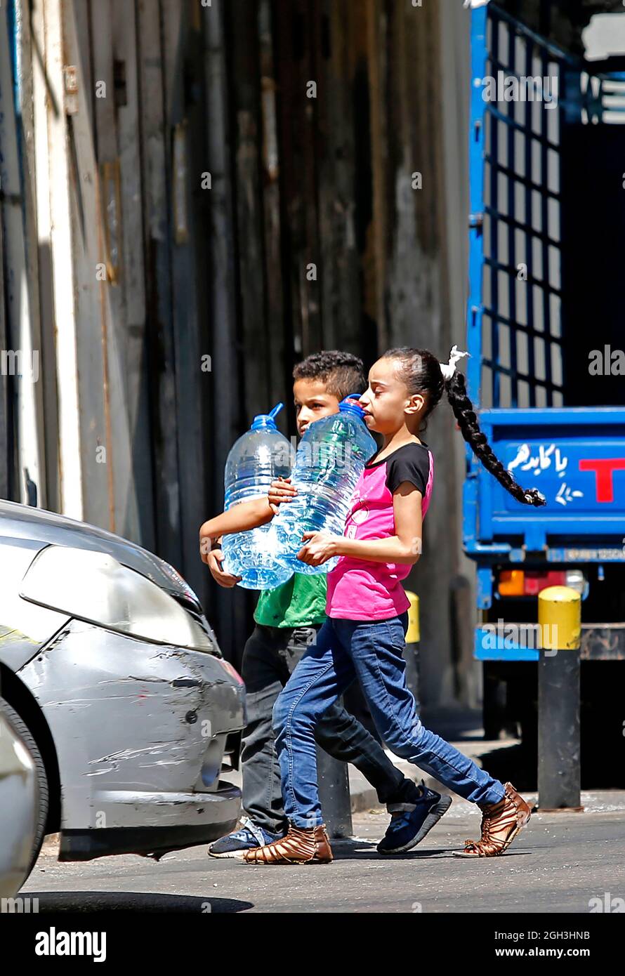 Beirut, Lebanon. 4th Sep, 2021. Children carry water in Beirut, Lebanon, on Sept. 4, 2021. Lebanon's multifaceted crises are having severe impacts on children which account for about one-third of the total population, said a senior UNICEF official over the weekend. Credit: Bilal Jawich/Xinhua/Alamy Live News Stock Photo
