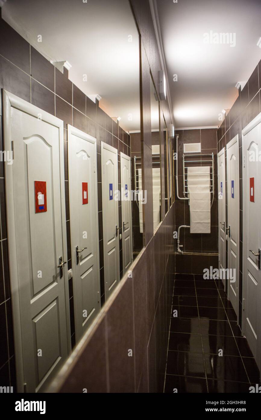 Hall with many doors. Narrow hall with a lot of mirrors and doors, walls and floors are finished with tiles Stock Photo