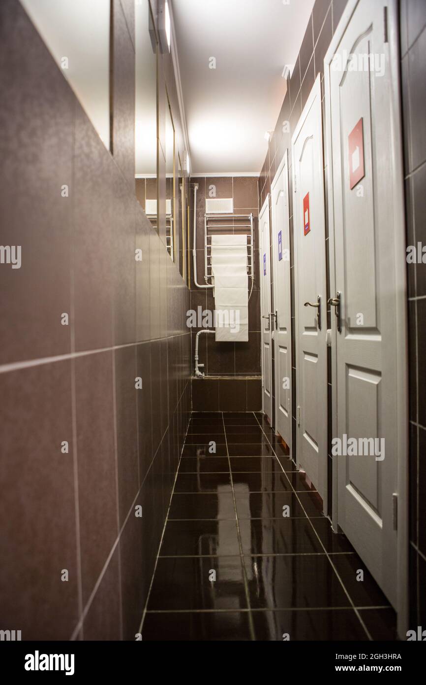 Hall with many doors. Narrow hall with a lot of mirrors and doors, walls and floors are finished with tiles Stock Photo