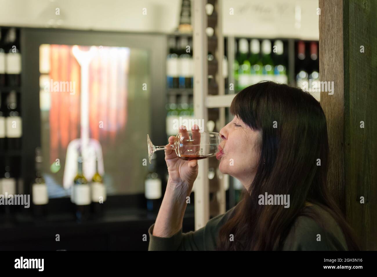A single female tourist enjoys a wine tasting session after a tour of the McGuigan's winery in the Hunter Valley in New South Wales, Australia. Stock Photo