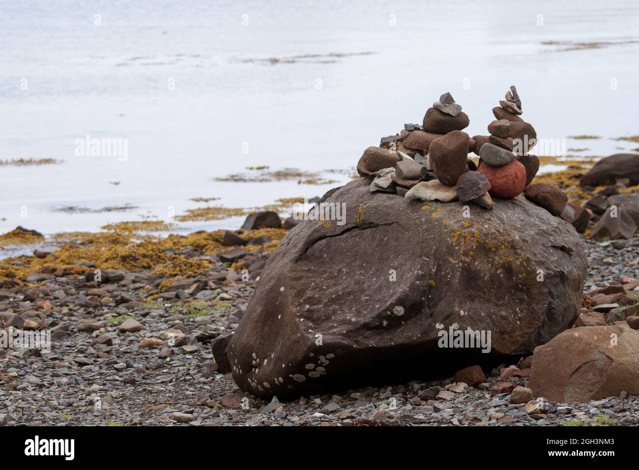 A pile of stones on a boulder on a rocky beach in Grand Manan Stock Photo