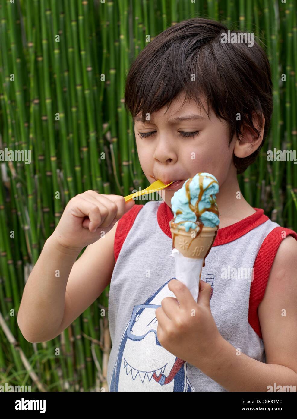 A Boy Wearing A White Shirt Is Eating Ice Cream Stock Photo