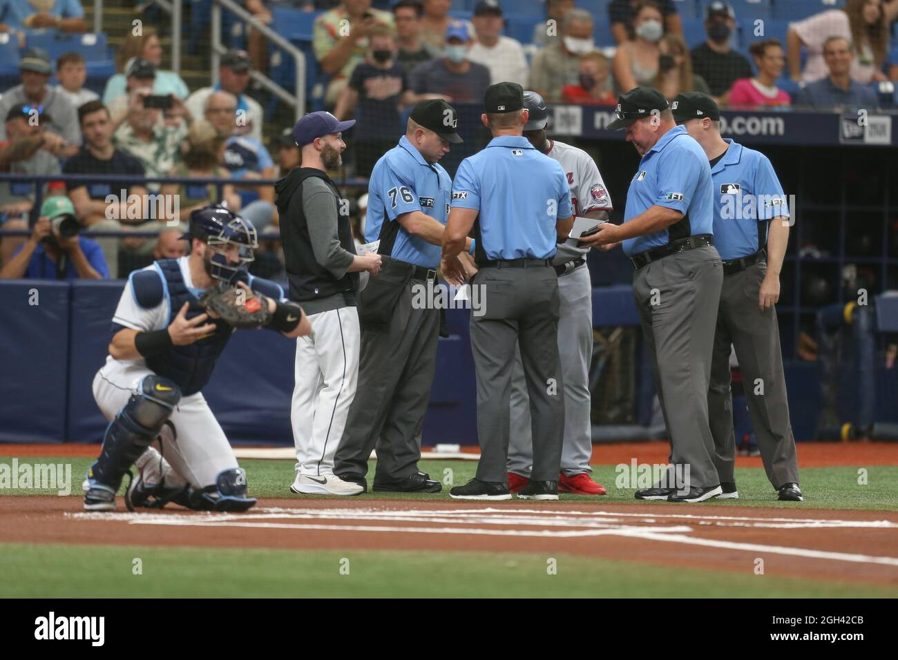 St. Petersburg, FL. USA;  The umpires and assistant coaches meet at the mound prior to a major league baseball game between the Tampa Bay Rays and the Stock Photo