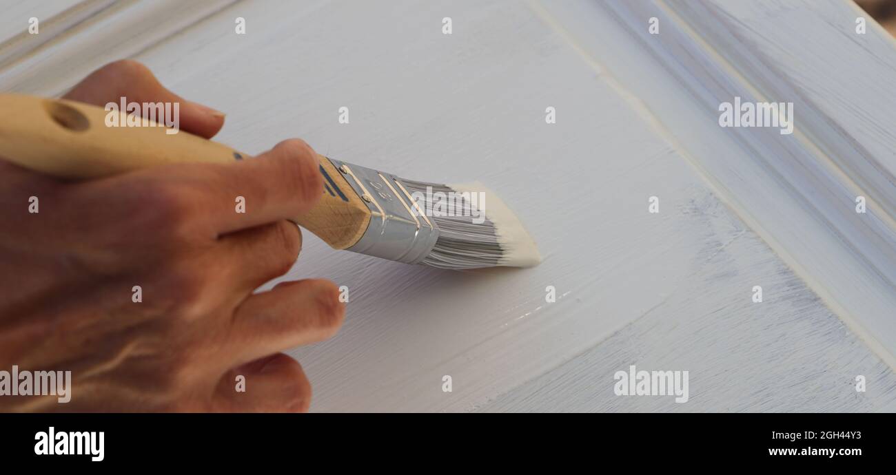 a brown kitchen cabinet is painted with white chalk paint Stock Photo