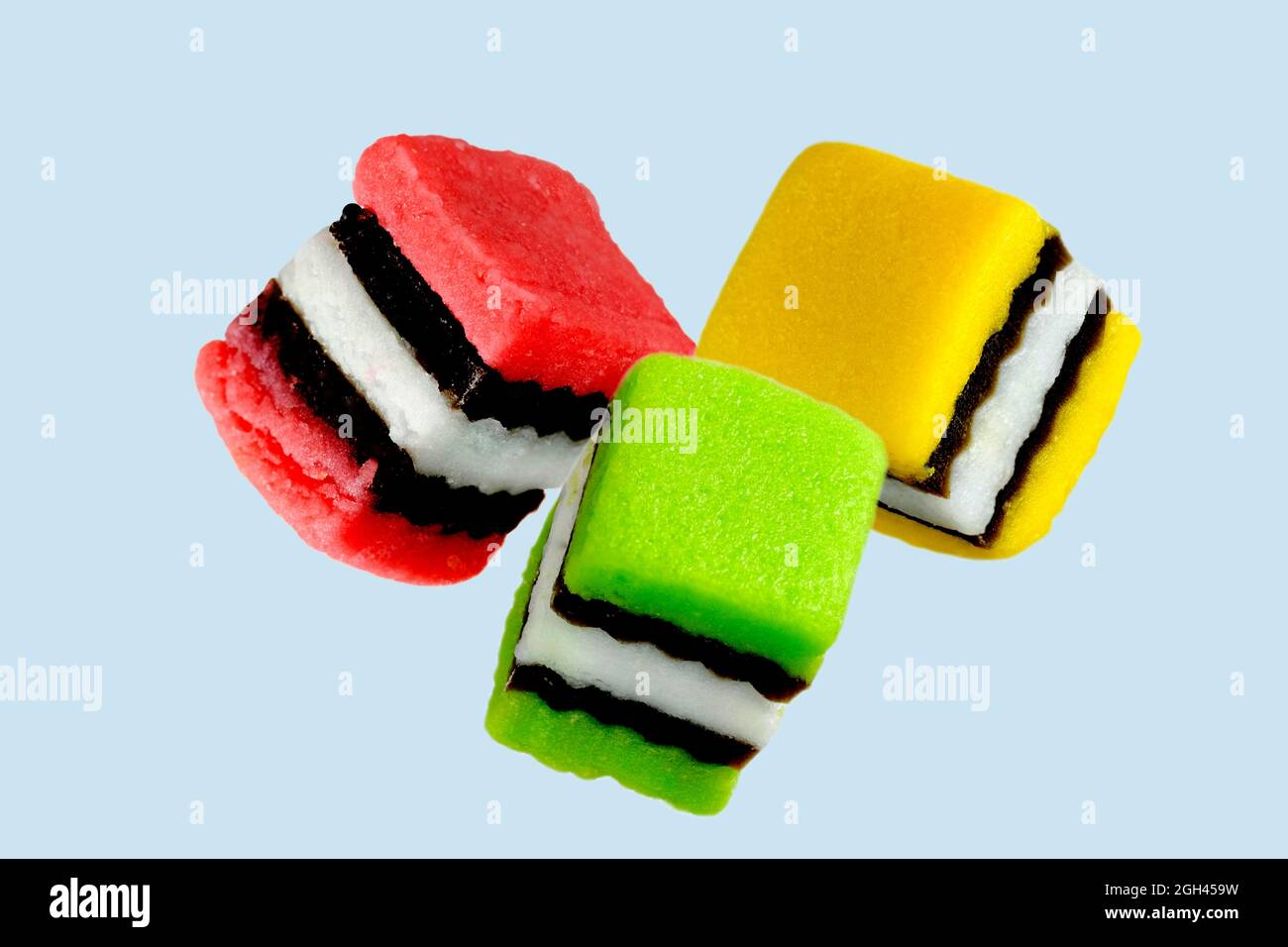 Liquorice allsorts, three, red green yellow on light blue background