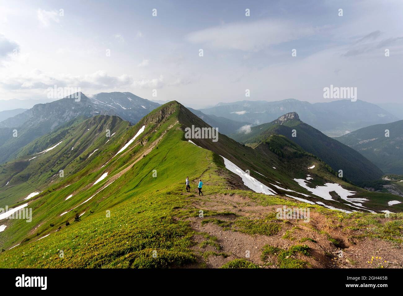 Tourists hiking on mountain ridge to the top of the Maja e Vajushës ...