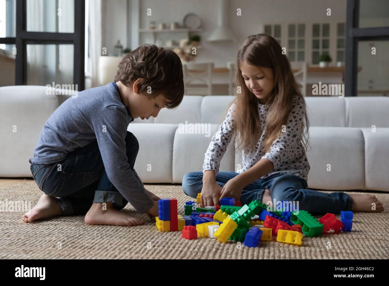 Cute sibling kids constructing toy tower, completing model Stock Photo